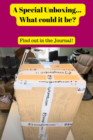 Picture of a LennyLamb shipping carton on a table in the warehouse at Mama & Roo's. Text reads, "A Special Unboxing... What could it be? Find out in the Journal!"