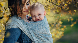 Baby smiles in a front carry in linen long woven wrap print Terra Rustle