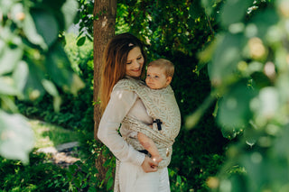 A mom carrying her baby in the LennyLamb Hybrid, Infinity - Golden Hour design. 