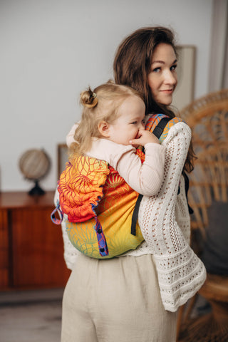 Preschool size wrap conversion waist-less onbuhimo baby backpack carrier for children from 3-7 years old in cotton woven design Rainbow Lotus, a jacquard weave with a bold rainbow gradient under an outlined repeating lotus flower pattern