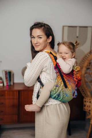 Preschool size wrap conversion waist-less onbuhimo baby backpack carrier for children from 3-7 years old in cotton woven design Rainbow Lotus, a jacquard weave with a bold rainbow gradient under an outlined repeating lotus flower pattern