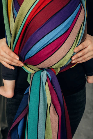 Lenny Lamb Long Woven Wrap - Carousel of Colors - Fabric close up in front carry. Wrap has horizontal stripes in rainbow colors with thin black stripes in-between the colors
