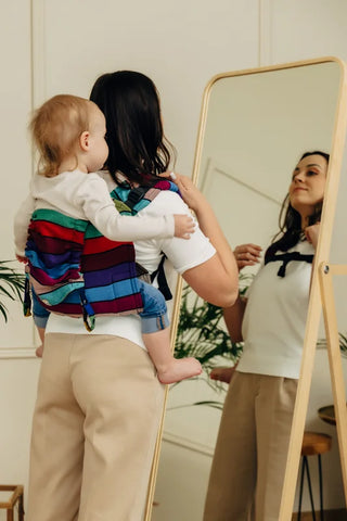 Lenny Lamb Onbuhimo PRO Toddler - Carousel of Colors. Image of woman with a toddler in the carrier on her back. Back view.