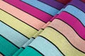 Lenny Lamb Long Woven Wrap - Carousel of Colors - Fabric close up. Wrap has horizontal stripes in rainbow colors with thin black stripes in-between the colors