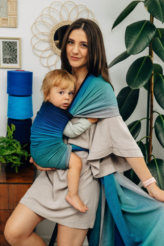Long woven baby wrap baby carrier  in cotton woven design Airglow, a broken twill weave in an ombre gradient blue to turquoise to grey