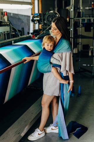 Long woven baby wrap baby carrier  in cotton woven design Airglow, a broken twill weave in an ombre gradient blue to turquoise to grey