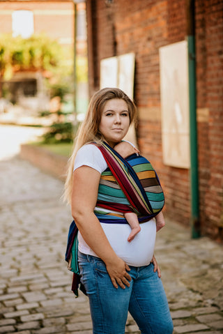 Lenny Lamb Long Woven Wrap - Carousel of Colors - newborn FWCC side view. Wrap has horizontal stripes in rainbow colors with thin black stripes in-between the colors