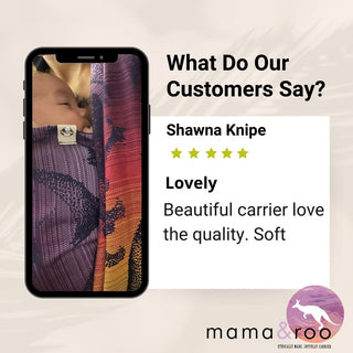 Customer photo of newborn in Jurassic Park New Era wrap. Text read, "What do our customers say? Shawna Knipe [5 stars] Lovely. Beautiful carrier love the quality. Soft" Bottom right logo, text reads, "mama & roo. Ethically made, joyfully carried"